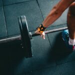 Hombre y mujer mayores de 40 entrenando al aire libre con pesas y sonriendo, representando el fitness después de los 40